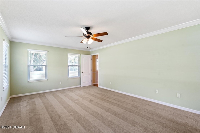 empty room featuring light carpet, crown molding, ceiling fan, and a textured ceiling