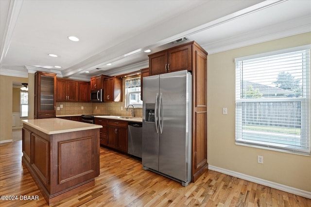 kitchen featuring crown molding, a kitchen island, light hardwood / wood-style floors, and appliances with stainless steel finishes