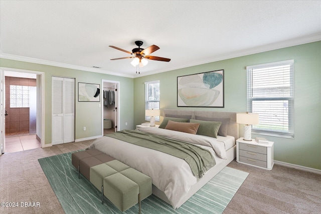 bedroom with ensuite bathroom, ceiling fan, and multiple windows