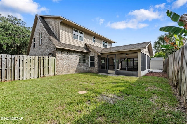 rear view of property featuring a sunroom and a yard