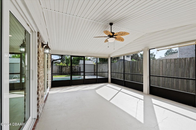 unfurnished sunroom with ceiling fan, wood ceiling, and vaulted ceiling