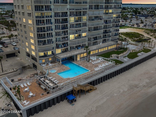 pool at dusk featuring a patio