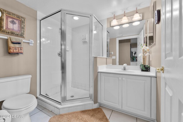 bathroom featuring vanity, tile patterned floors, toilet, and an enclosed shower