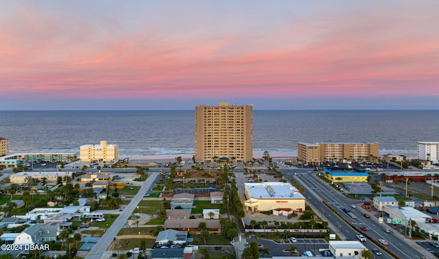 aerial view at dusk featuring a water view