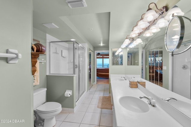 bathroom featuring vanity, a shower with door, tile patterned floors, and toilet