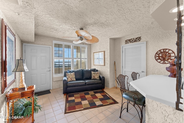 tiled living room with a textured ceiling and ceiling fan