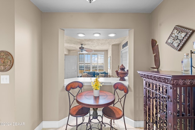 tiled dining area featuring a textured ceiling and ceiling fan