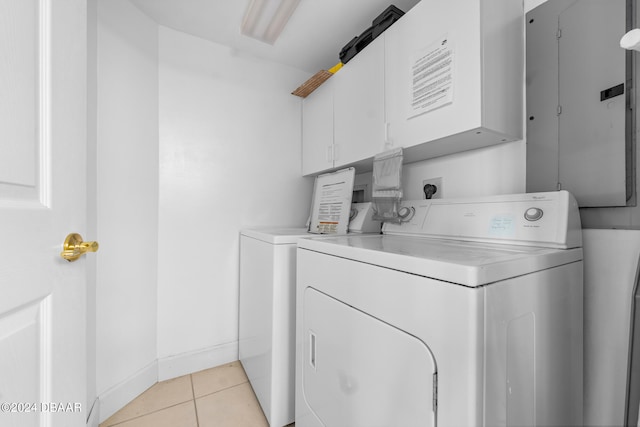 laundry room featuring electric panel, cabinets, light tile patterned floors, and separate washer and dryer