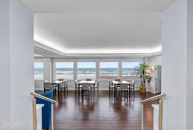 dining room featuring dark wood-type flooring and a water view