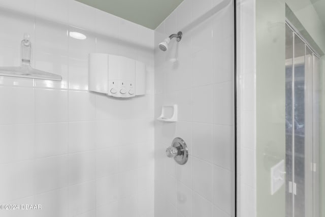 bathroom featuring a shower with door