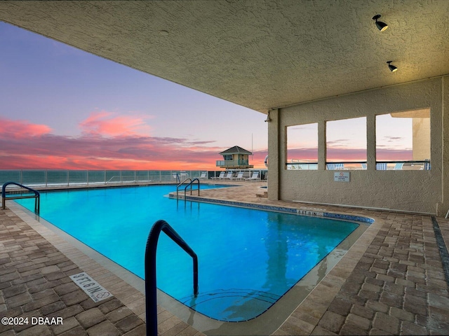 pool at dusk with a patio