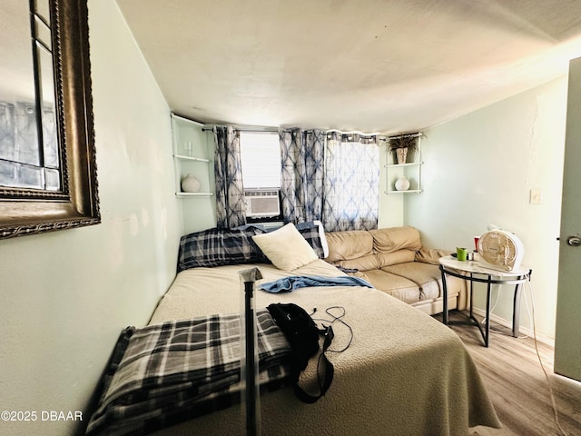 1228 Leon Ln, Daytona Beach, FL 32117 - bedroom with wood finished floors, cooling unit, and baseboards