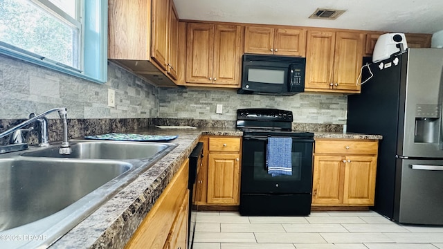 1228 Leon Ln, Daytona Beach, FL 32117 - kitchen with black appliances, a sink, backsplash, and brown cabinetry