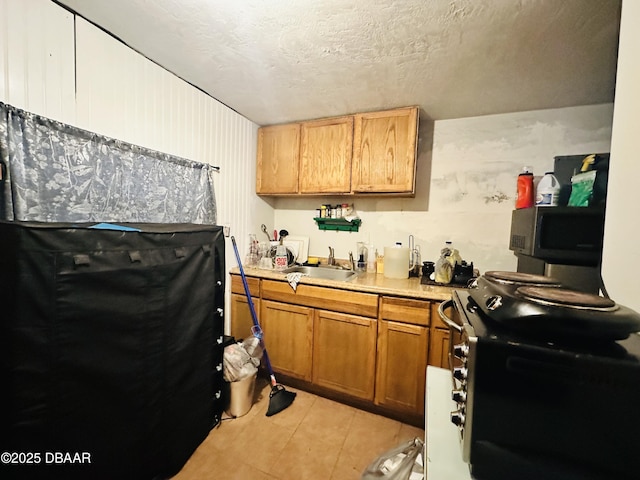 1228 Leon Ln, Daytona Beach, FL 32117 - kitchen with a sink, appliances with stainless steel finishes, light tile patterned floors, light countertops, and a textured ceiling