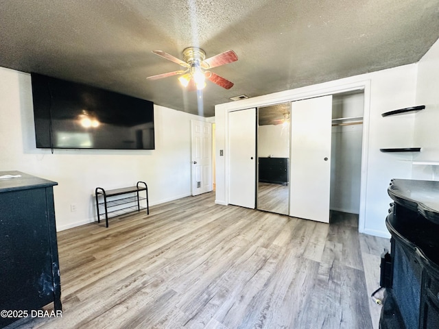 1228 Leon Ln, Daytona Beach, FL 32117 - unfurnished bedroom with wood finished floors, a textured ceiling, a closet, baseboards, and ceiling fan