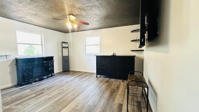 1228 Leon Ln, Daytona Beach, FL 32117 - unfurnished bedroom with wood finished floors, a textured ceiling, baseboards, and ceiling fan