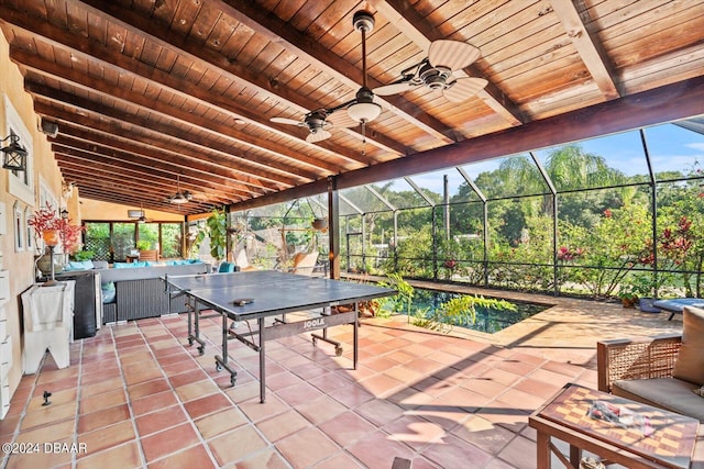 view of patio featuring ceiling fan and glass enclosure