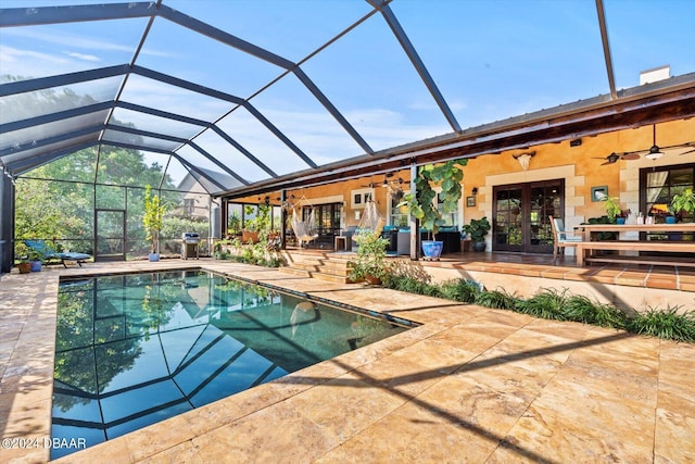 view of pool with glass enclosure, french doors, ceiling fan, and a patio area