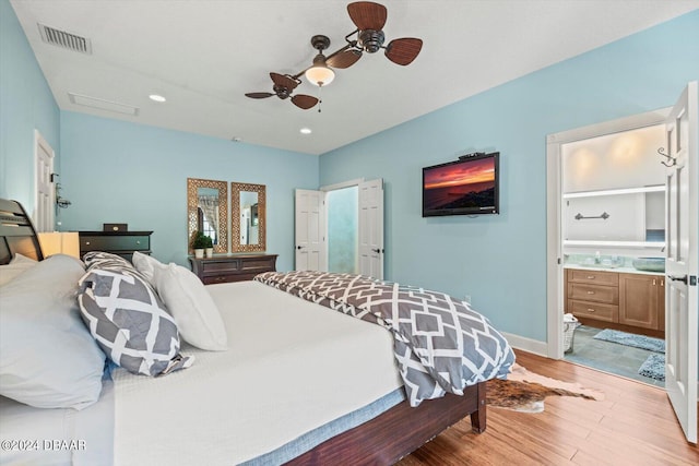 bedroom featuring light wood-type flooring, ceiling fan, and ensuite bath