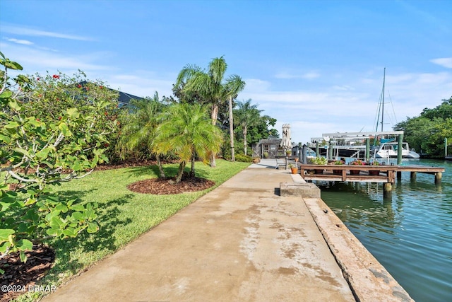 dock area with a water view and a lawn