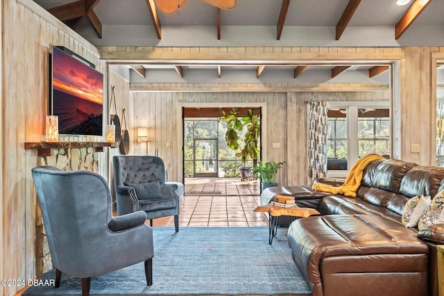 sitting room with plenty of natural light, wooden walls, and beam ceiling