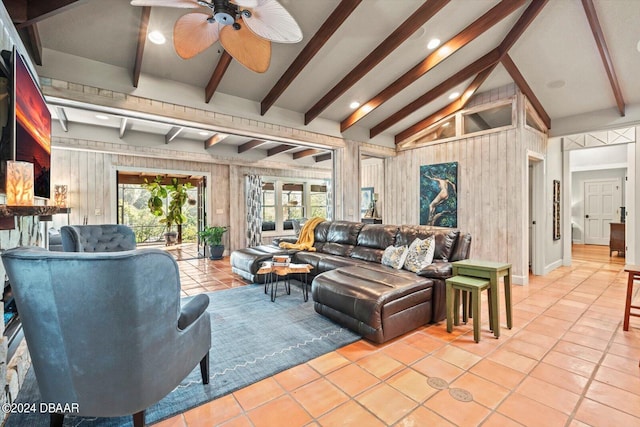 living room with wood walls, light tile patterned flooring, ceiling fan, and vaulted ceiling with beams