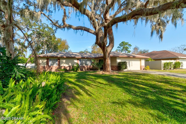 single story home featuring a garage and a front lawn