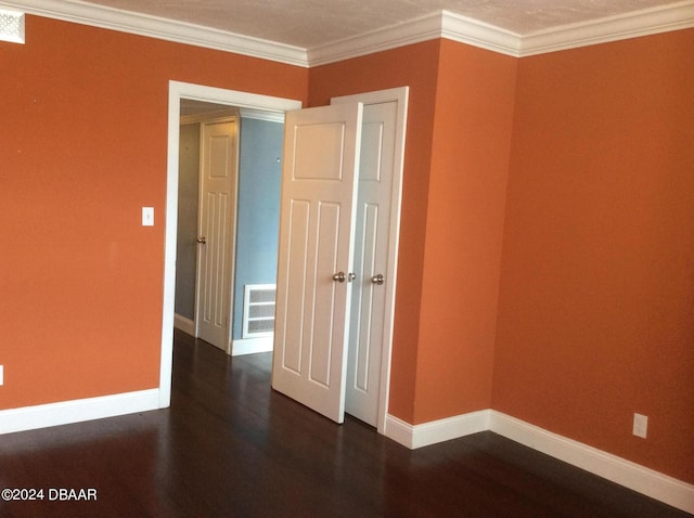 unfurnished room with dark wood-type flooring and crown molding