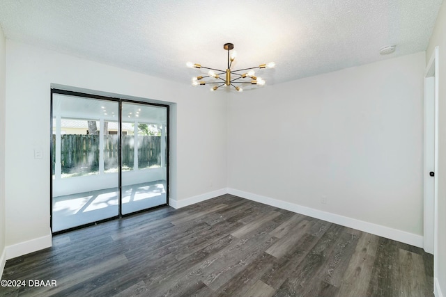 unfurnished room with dark hardwood / wood-style flooring, a chandelier, and a textured ceiling