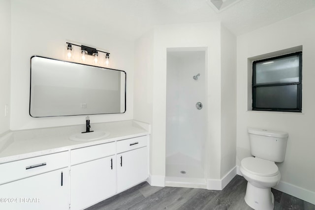 bathroom featuring toilet, a shower, wood-type flooring, a textured ceiling, and vanity