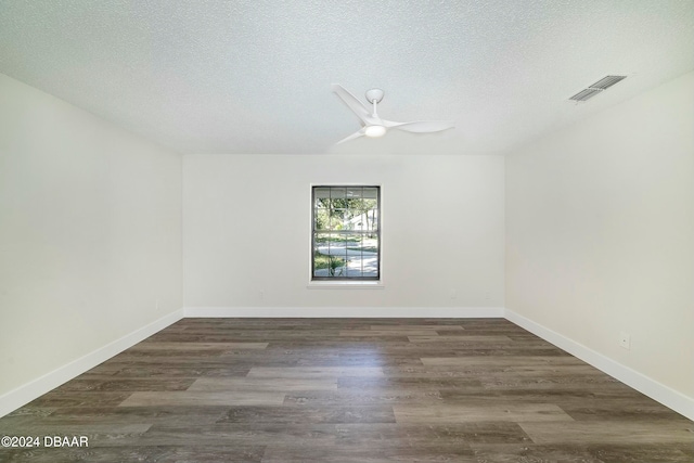 spare room with dark wood-type flooring, ceiling fan, and a textured ceiling