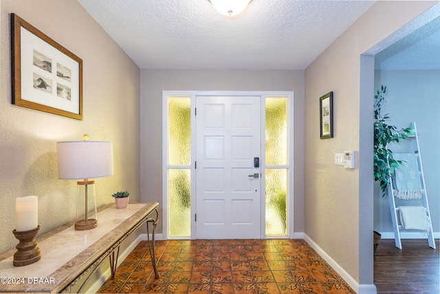 foyer with a textured ceiling and dark wood-type flooring