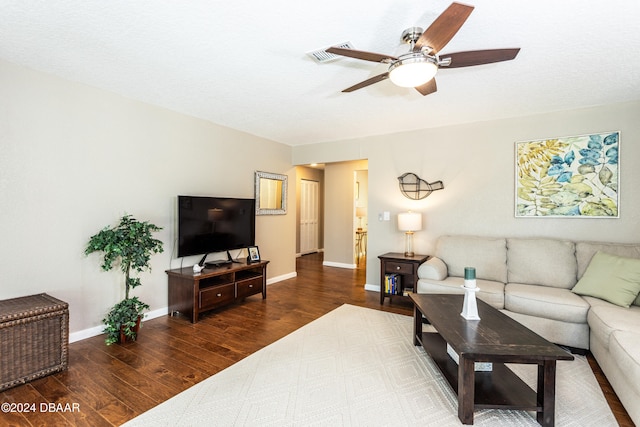 living room featuring ceiling fan, dark hardwood / wood-style flooring, and a textured ceiling