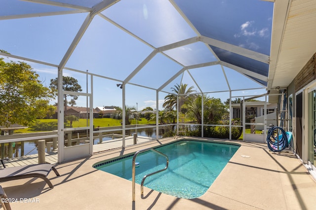 view of swimming pool with a patio area, a water view, and glass enclosure