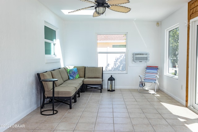 living area with a wall mounted air conditioner, ceiling fan, light tile patterned floors, and a skylight