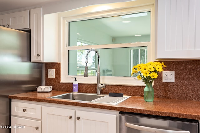 kitchen featuring backsplash, stainless steel appliances, white cabinetry, and sink