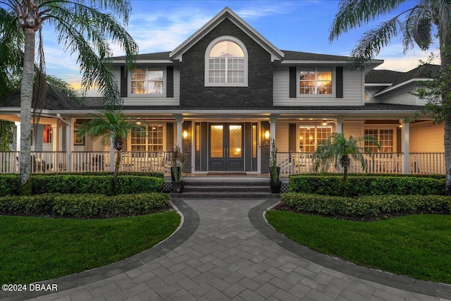 view of front of house with a lawn and a porch