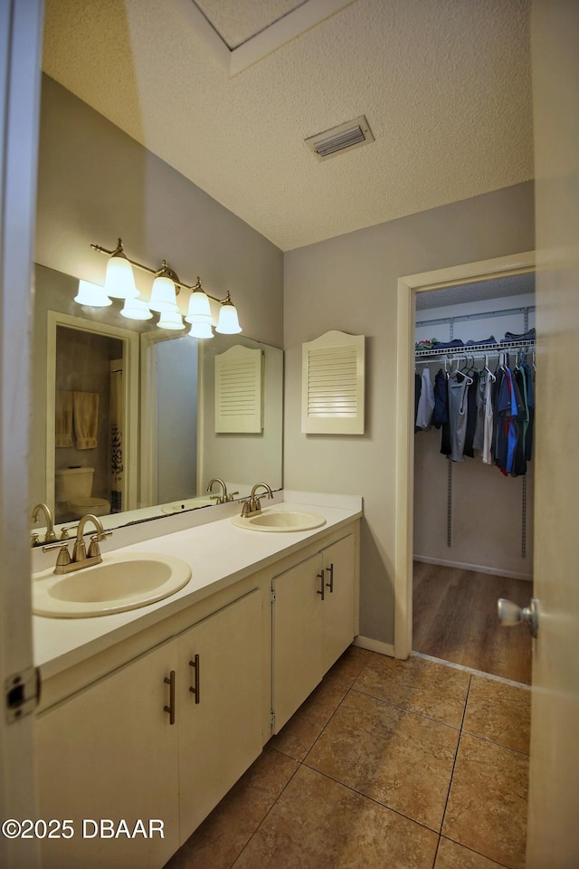 bathroom featuring tile patterned floors, vanity, and a textured ceiling