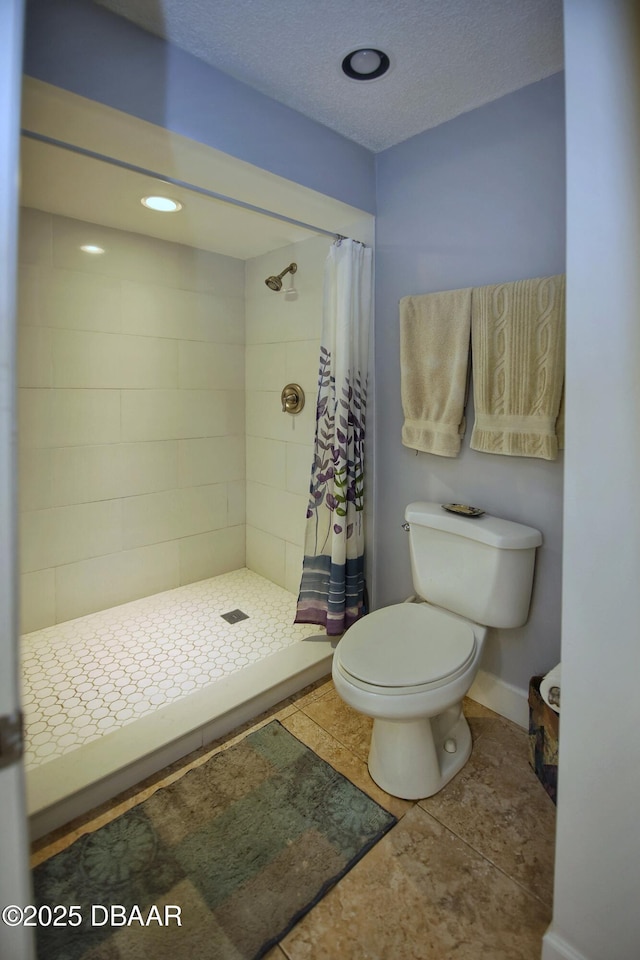 bathroom with a textured ceiling, a shower with shower curtain, tile patterned floors, and toilet