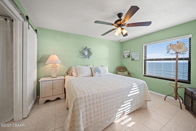 3100 Ocean Shore Blvd Unit 5020, Ormond Beach, FL 32176 - bedroom with light tile patterned flooring, a barn door, baseboards, and a ceiling fan