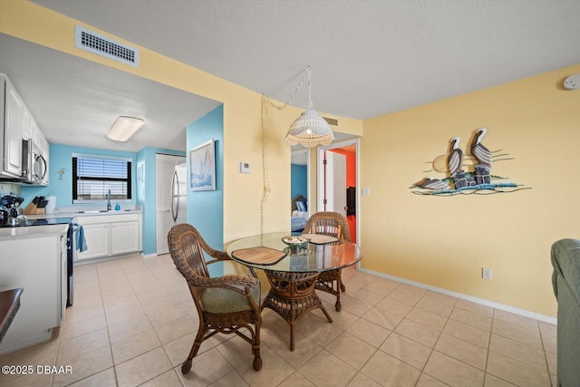 3100 Ocean Shore Blvd Unit 5020, Ormond Beach, FL 32176 - dining area featuring light tile patterned floors, a textured ceiling, and baseboards