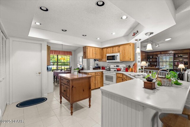 5 Southern Pine Trl, Ormond Beach, FL 32174 - kitchen with white appliances, a peninsula, a textured ceiling, light countertops, and pendant lighting