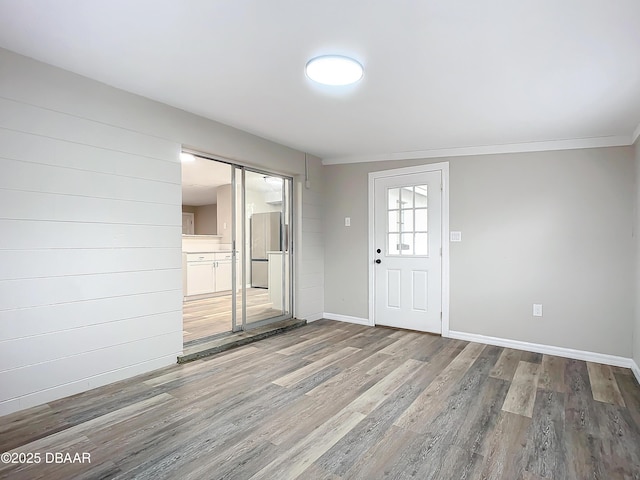 entrance foyer featuring baseboards, ornamental molding, and wood finished floors