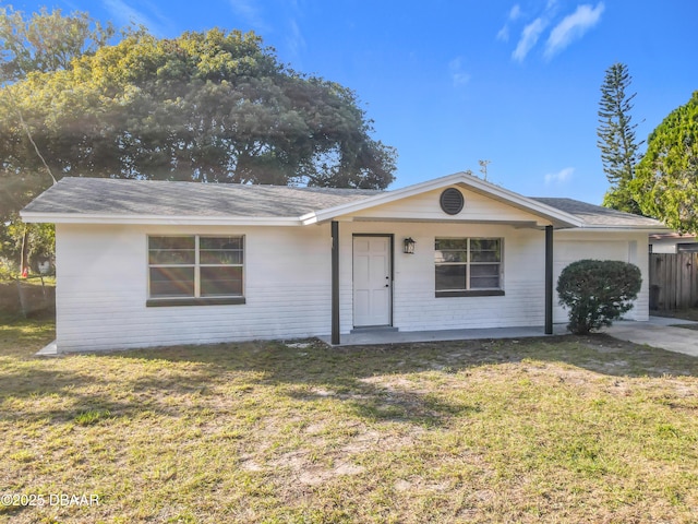 ranch-style house featuring covered porch, an attached garage, and a front lawn