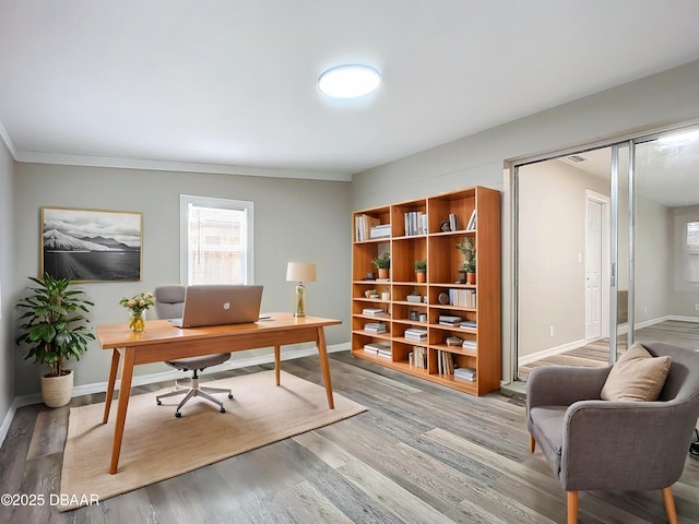 home office featuring crown molding, baseboards, and wood finished floors