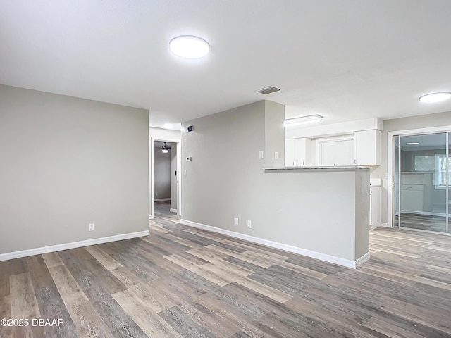 unfurnished living room with visible vents, baseboards, and light wood-type flooring