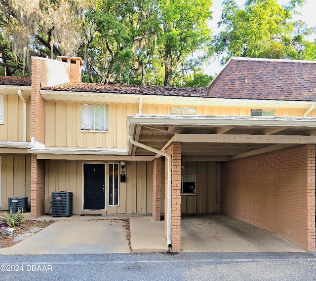 view of front facade with central AC unit and a carport