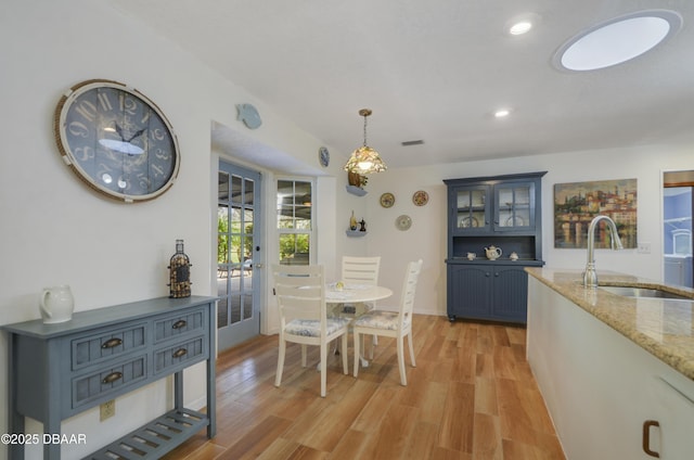 dining space featuring sink and light wood-type flooring