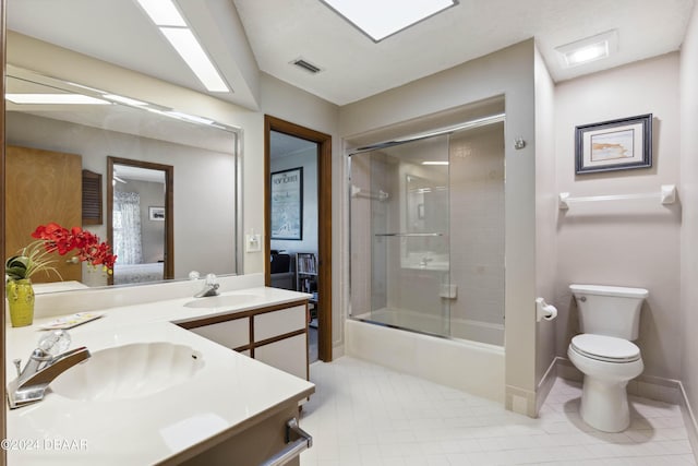 full bathroom featuring enclosed tub / shower combo, vanity, toilet, and tile patterned floors