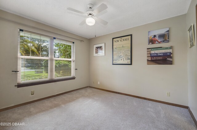 spare room featuring light colored carpet and ceiling fan